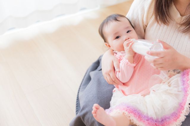 親にミルクを飲ませてもらう赤ちゃん